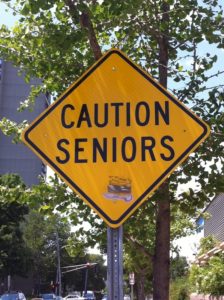 A caution sign is posted on the side of a road.