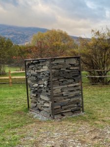 A stone structure in the middle of a field.