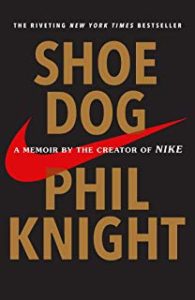 A book cover with nike logo and the words " shoe dog phil knight."