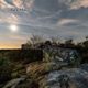 A view of the sun setting over a rocky area.