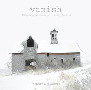 A barn with snow on it and the word vanish written in front of it.