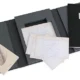 A black and white photo album with some papers