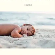 life on earth A baby laying on the beach in front of the ocean.