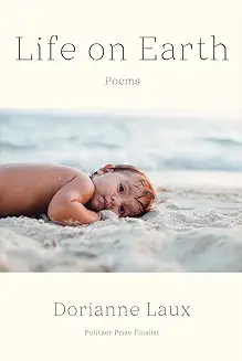 A baby laying on the beach in front of the ocean.